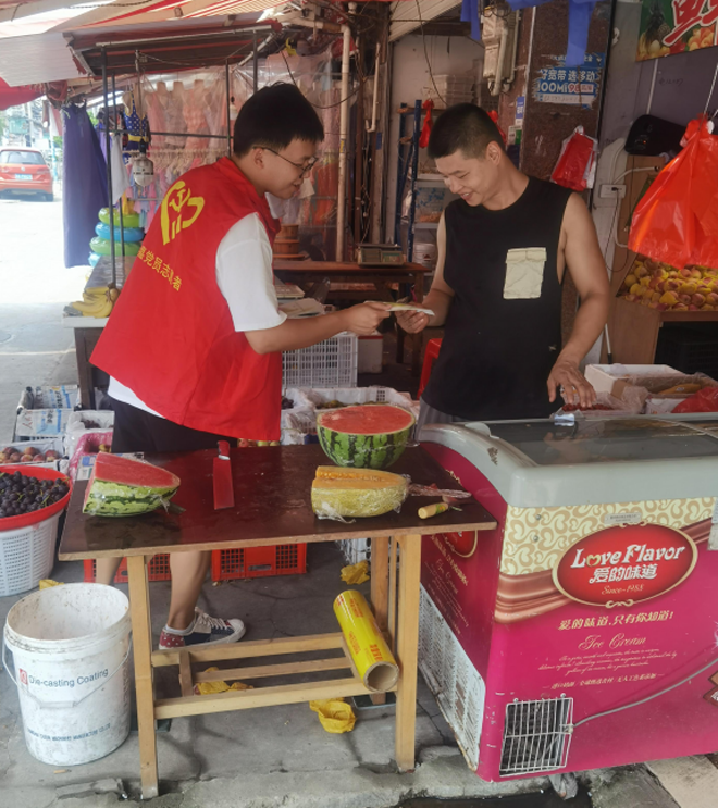 黄田街道志愿者到农贸市场对水果商户内进行垃圾分类知识宣传